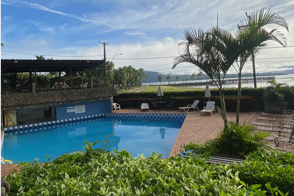 vista do pátio do hotel camboa em Antonina com piscina azul e ao fundo a báia de antonina